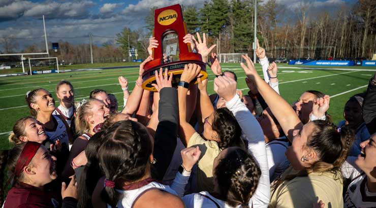 Golden Bear field hockey players hoist the NCAA Championship trophy.